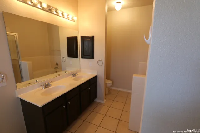 a bathroom with a sink a toilet and mirror