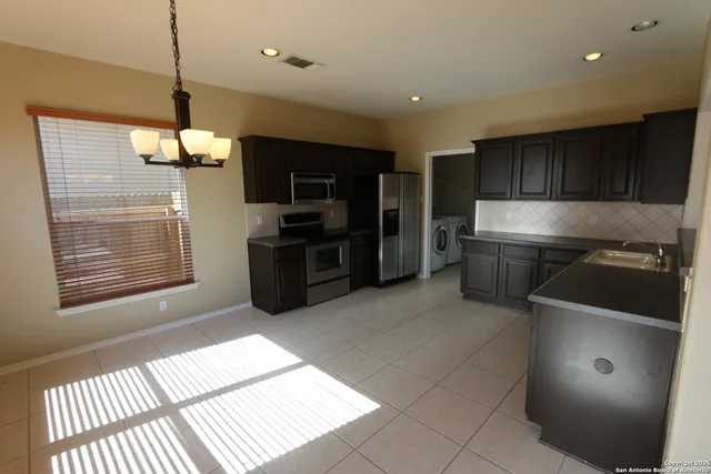 a kitchen with stainless steel appliances granite countertop a refrigerator and a stove top oven