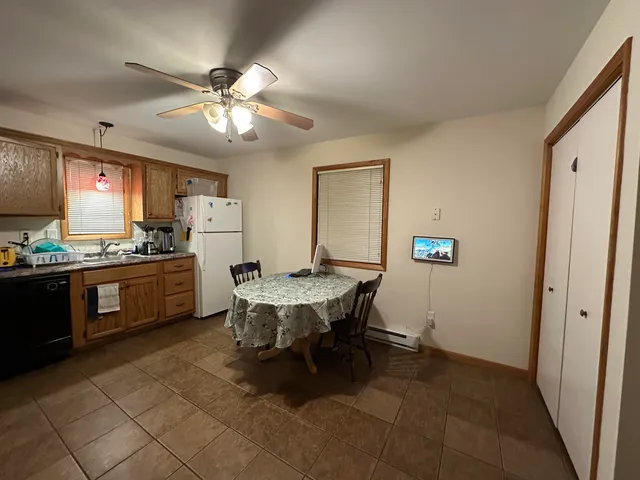 a kitchen with a table chairs refrigerator and cabinets
