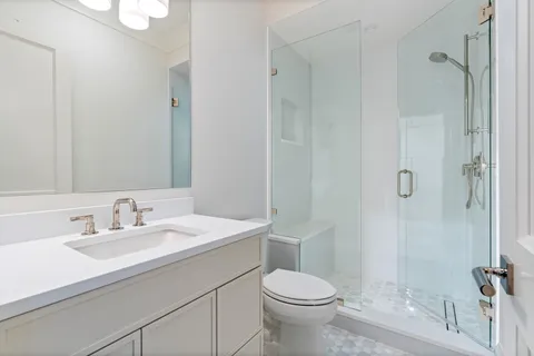 a bathroom with a sink a toilet and shower
