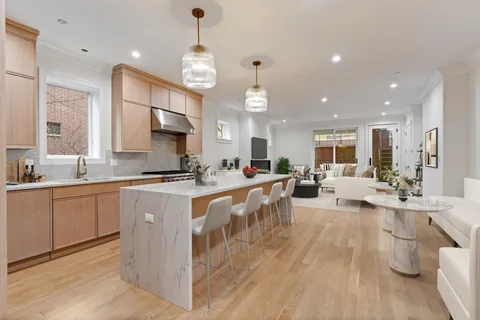 a large white kitchen with lots of counter space dining table and chairs