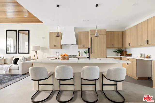 a kitchen with stainless steel appliances granite countertop a table chairs sink and cabinets