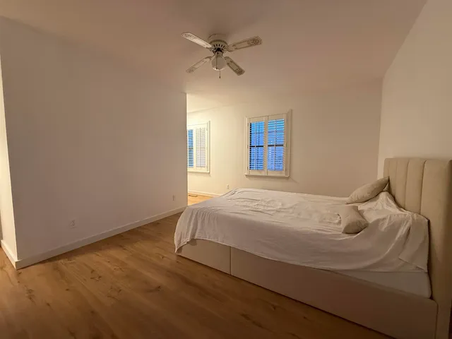a bedroom with a bed and a ceiling fan
