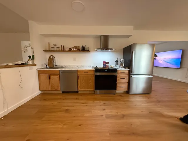 a kitchen with stainless steel appliances granite countertop a sink stove and refrigerator