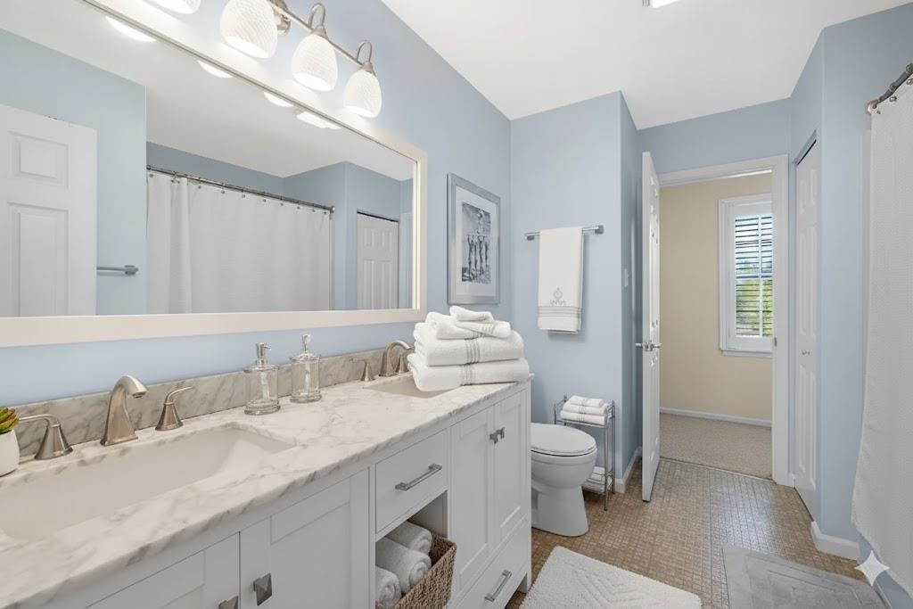 510 Portsmouth Road Cape May, NJ 08204 - Photo 9 of 41 a bathroom with a granite countertop sink a toilet and a large mirror