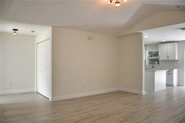 a view of empty room with wooden floor and windows