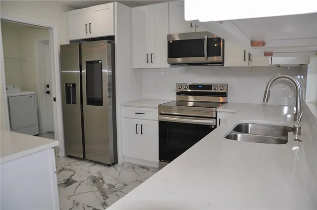 a kitchen with stainless steel appliances granite countertop a sink and a stove top oven