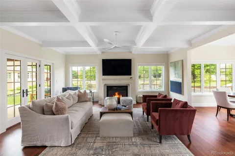 a living room with furniture a fireplace a flat screen tv and a large window