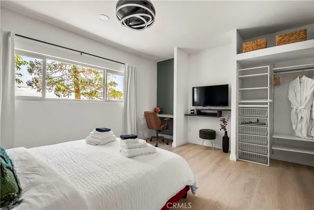 a bedroom with a bed and a flat tv screen on the dresser
