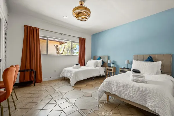 a bedroom with 2 bed and a window