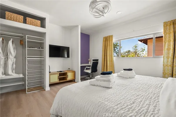 a bedroom with a bed and a tv on the dresser