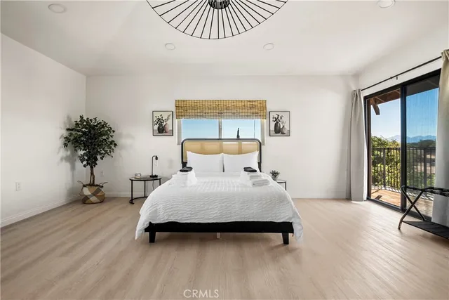 a bedroom with a bed and a large window with outer view