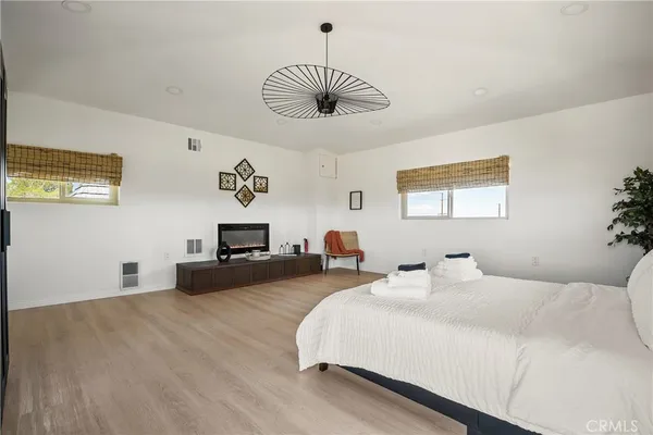 a spacious bedroom with a bed and a chandelier