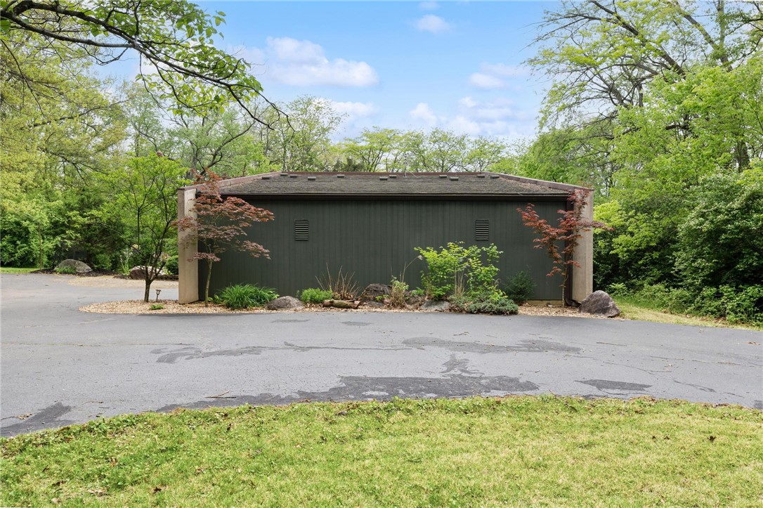 1940 Armstrong Road Fairborn, OH 45324 - Photo 3 of 48 A tranquil driveway leads to a private garage amidst lush, natural landscaping.