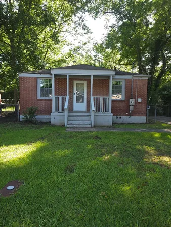 a backyard of a house with table and chairs
