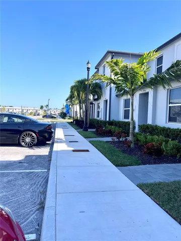 a front view of a house with a yard and potted plants
