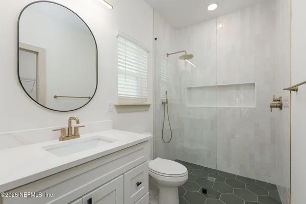 a bathroom with a sink a toilet and a mirror