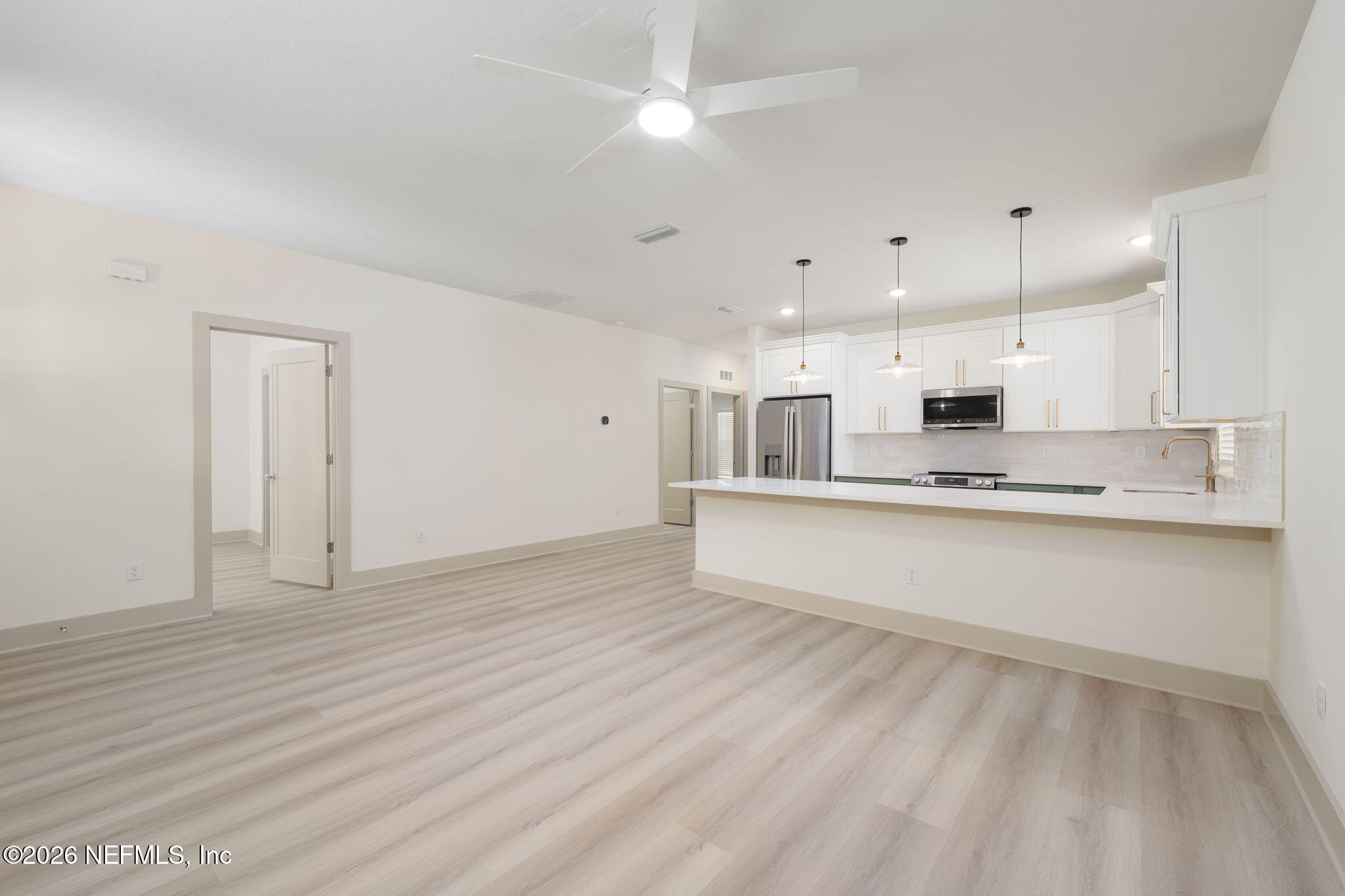 716 West 6th Street St. Augustine, FL 32084 - Photo 5 of 28 a large white kitchen with kitchen island a sink stainless steel appliances and cabinets