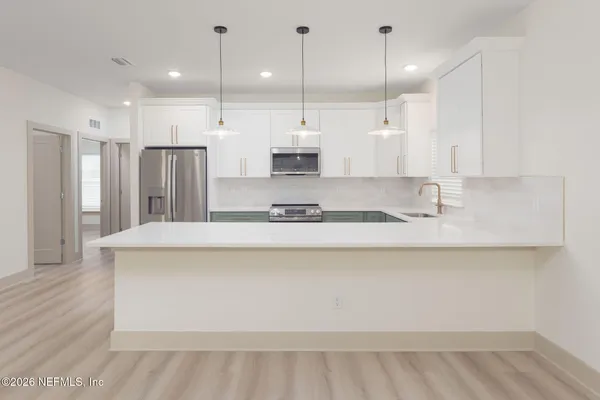 a kitchen with stainless steel appliances granite countertop a sink a refrigerator and a stove