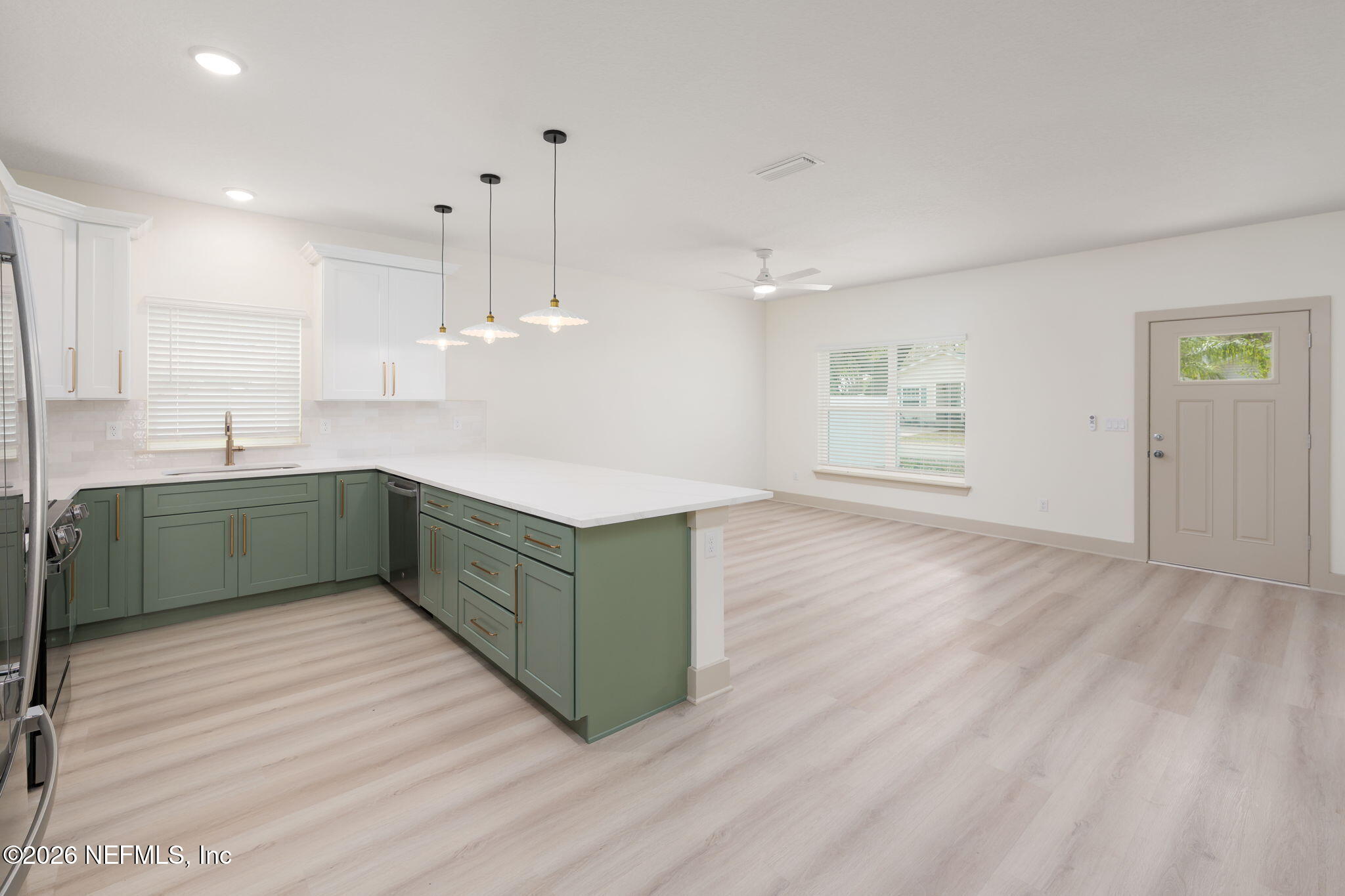 716 West 6th Street St. Augustine, FL 32084 - Photo 10 of 28 a kitchen with stainless steel appliances granite countertop a sink cabinets and wooden floor