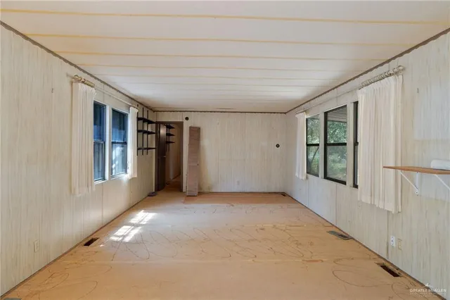 a view of livingroom with an empty space and windows