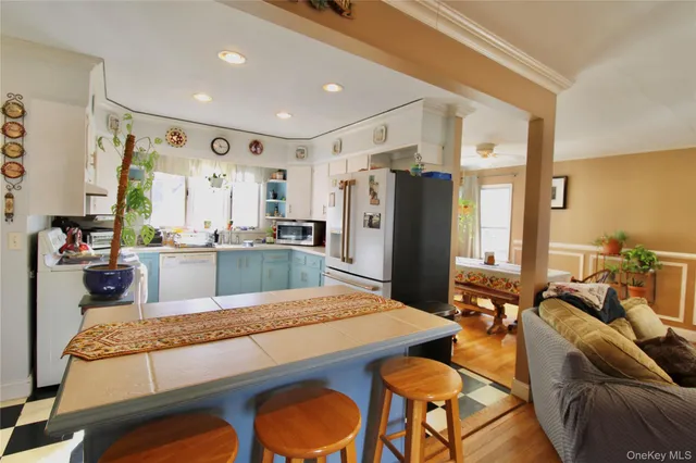 a kitchen with stainless steel appliances granite countertop a refrigerator a stove and white cabinets