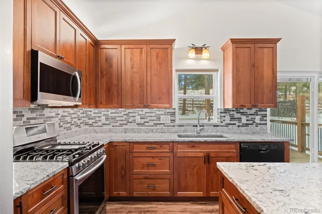 a kitchen with stainless steel appliances wooden cabinets and a stove top oven