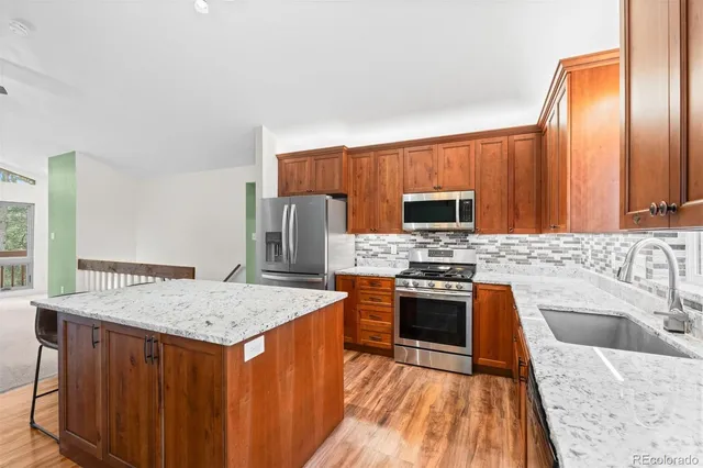 a kitchen with stainless steel appliances a stove sink and microwave