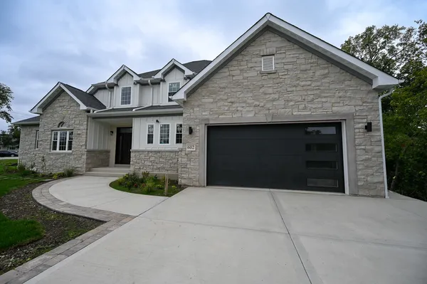 a view of a house with large windows and a yard