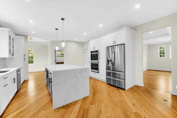 a view of a hallway with wooden floor and closet