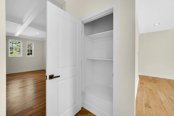 a spacious bedroom with a bed and wooden floor