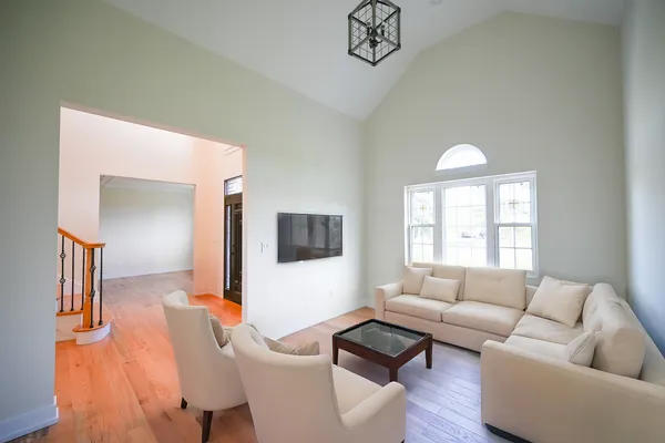 a view of empty room with wooden floor and fan