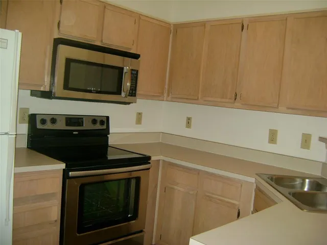 a kitchen with granite countertop white cabinets and black appliances