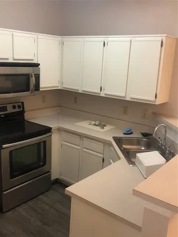 a kitchen with a sink stove and cabinets