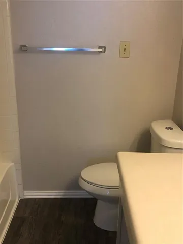 a white toilet sitting next to a shower