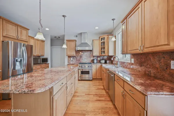 a view of a hallway with wooden floor and windows