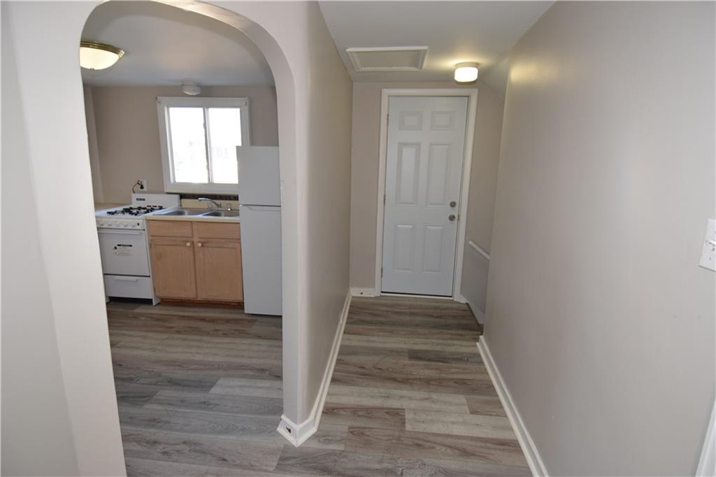 420 Jefferson Street Rochester, PA 15074 - Photo 5 of 19 a view of a hallway with wooden floor and a living room