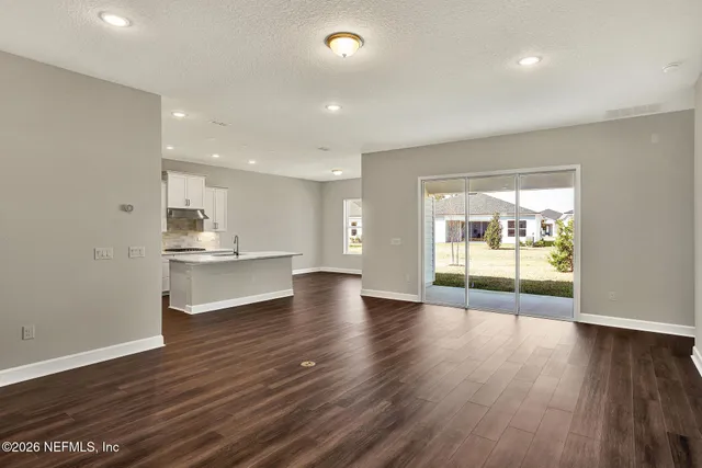 a view of room with wooden floor and white walls
