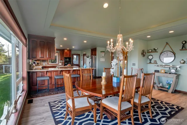 a dining room filled chandelier and wooden floor