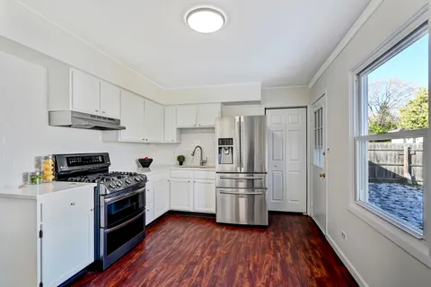 a kitchen with white cabinets and appliances