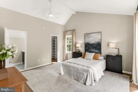 a bedroom with a large bed and a potted plant