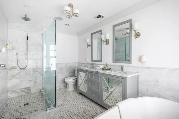 a bathroom with a granite countertop sink a toilet a mirror and shower