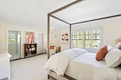 a bedroom with a large bed and a flat tv screen