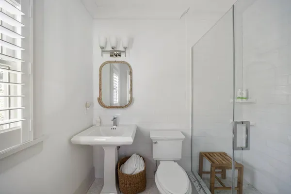 a bathroom with a toilet sink and mirror