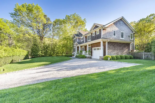 a front view of a house with a yard and trees