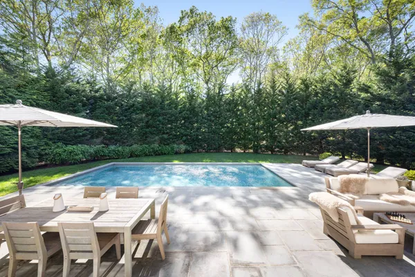 a view of backyard with swimming pool and patio