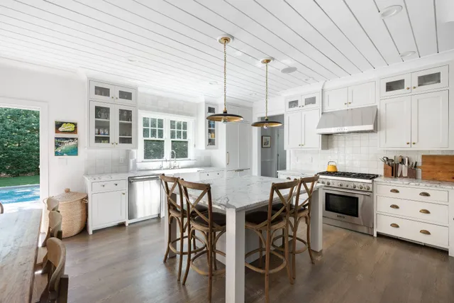 a kitchen with a table chairs stainless steel appliances and cabinets