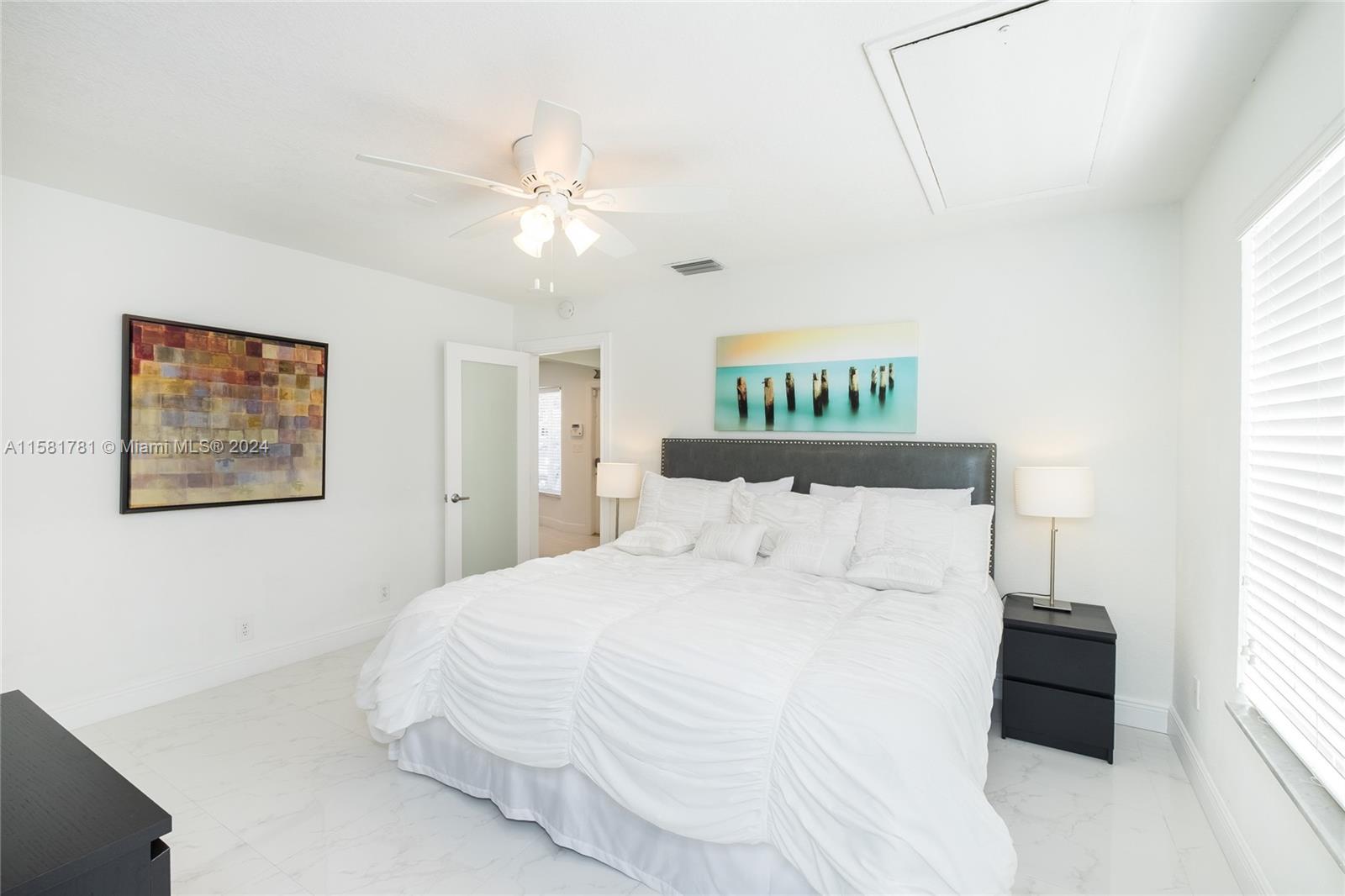 210 Southeast 4th Street Dania Beach, FL 33004 - Photo 5 of 16 a bedroom with a large bed and a chandelier