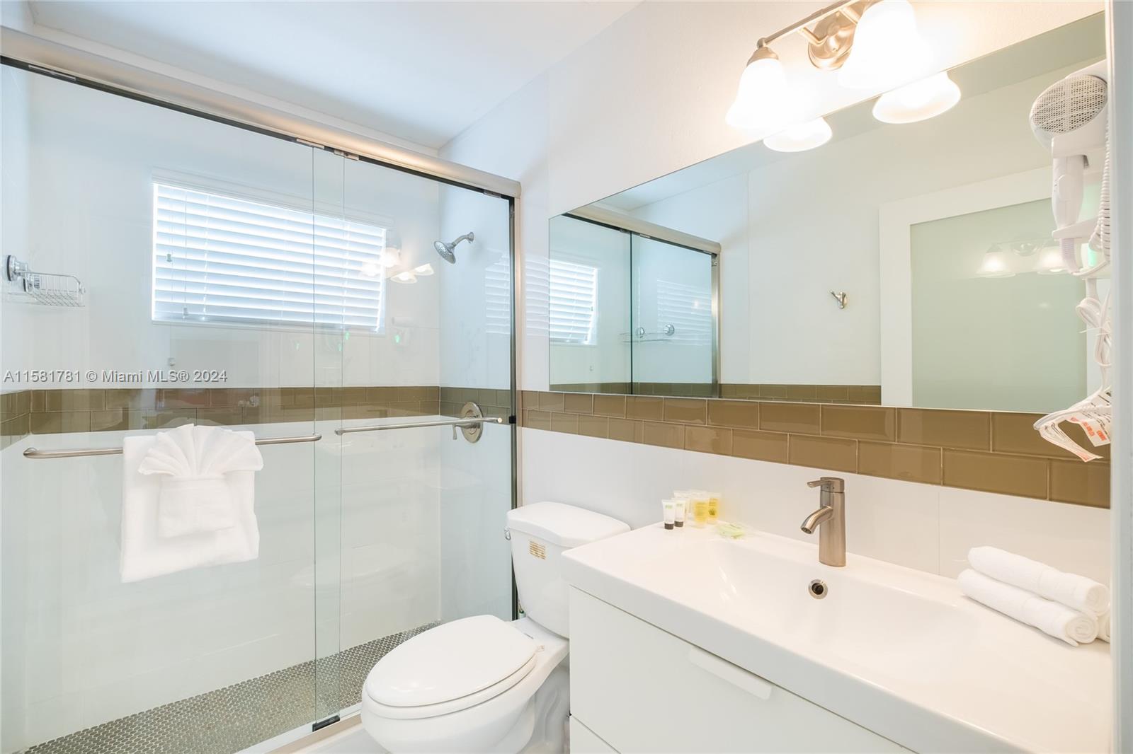 210 Southeast 4th Street Dania Beach, FL 33004 - Photo 8 of 16 a bathroom with a sink a toilet and a large mirror