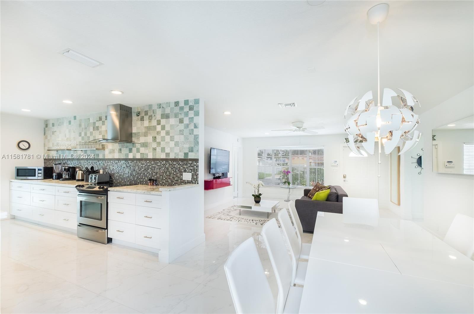 210 Southeast 4th Street Dania Beach, FL 33004 - Photo 9 of 16 a living room with kitchen island furniture and a chandelier